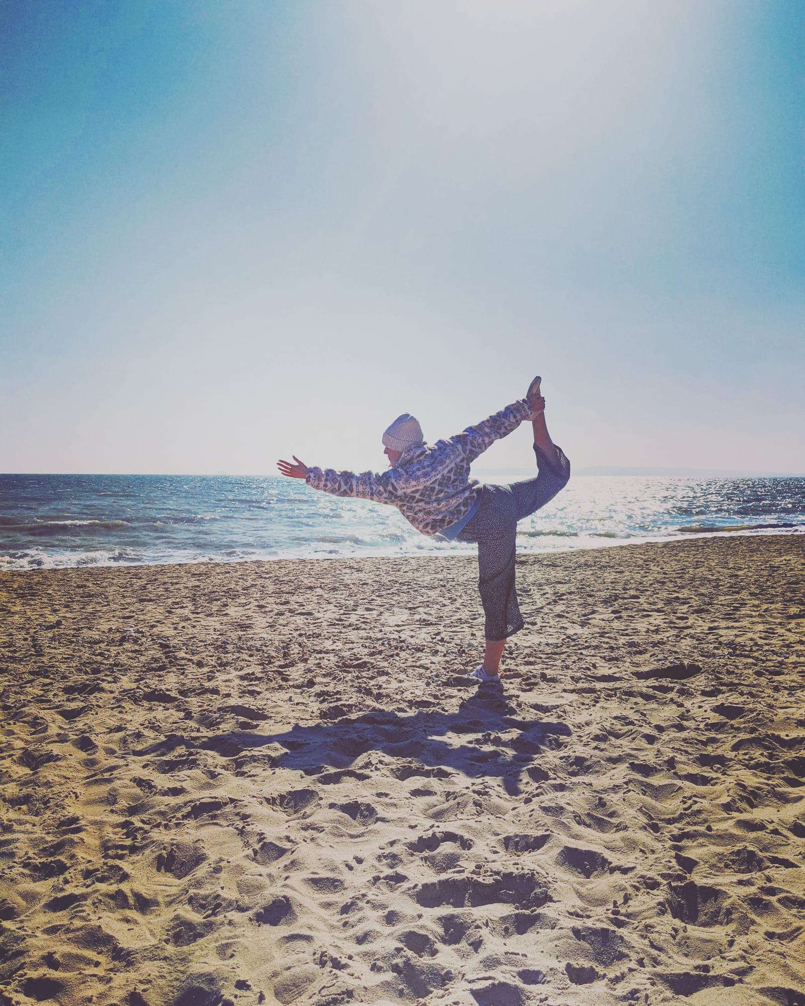 Rachael in a balancing yoga pose on the beach