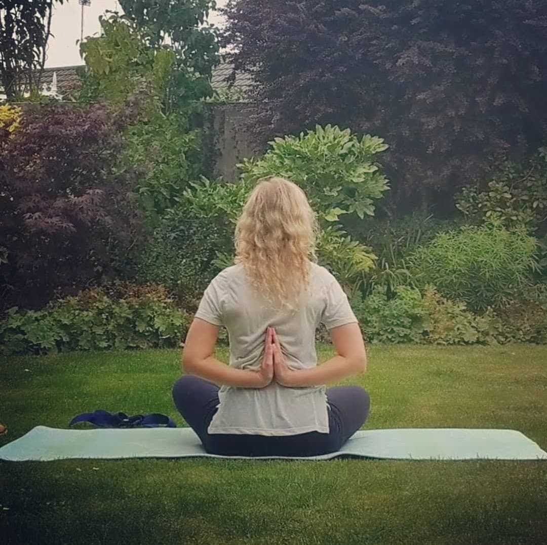 Rachael meditating in a garden